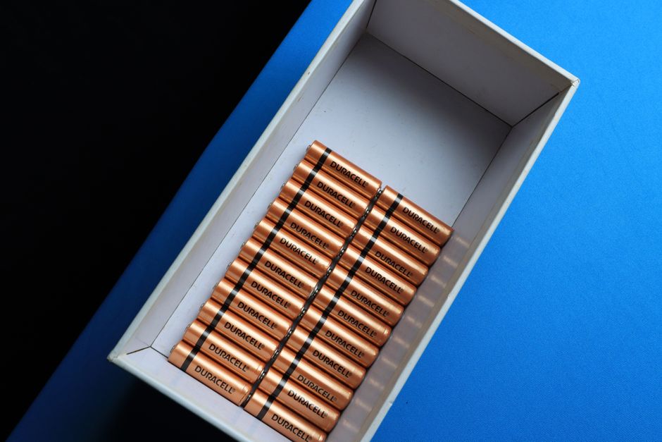 Accucontainers voor energieopslag bij een moderne woning met zonnepanelen en laadpaal.